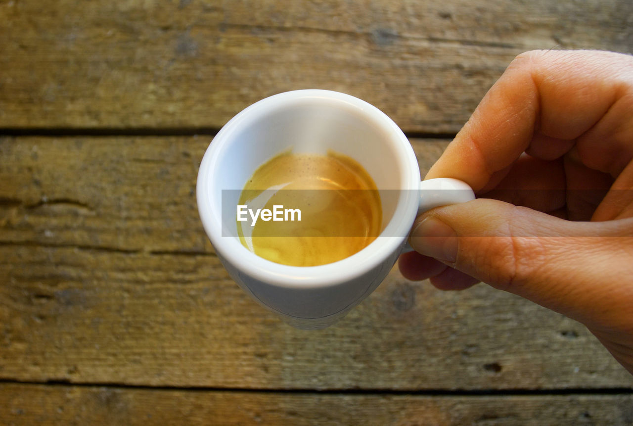 The first-person perspective of someone drinking from an espresso coffee cup.