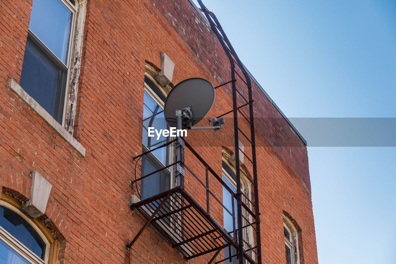 A fire escape on the side of a building and a satellite dish