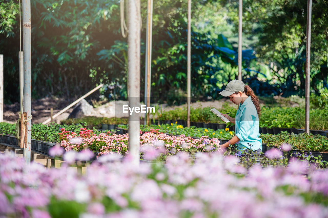 SIDE VIEW OF MAN WORKING AT FLOWER