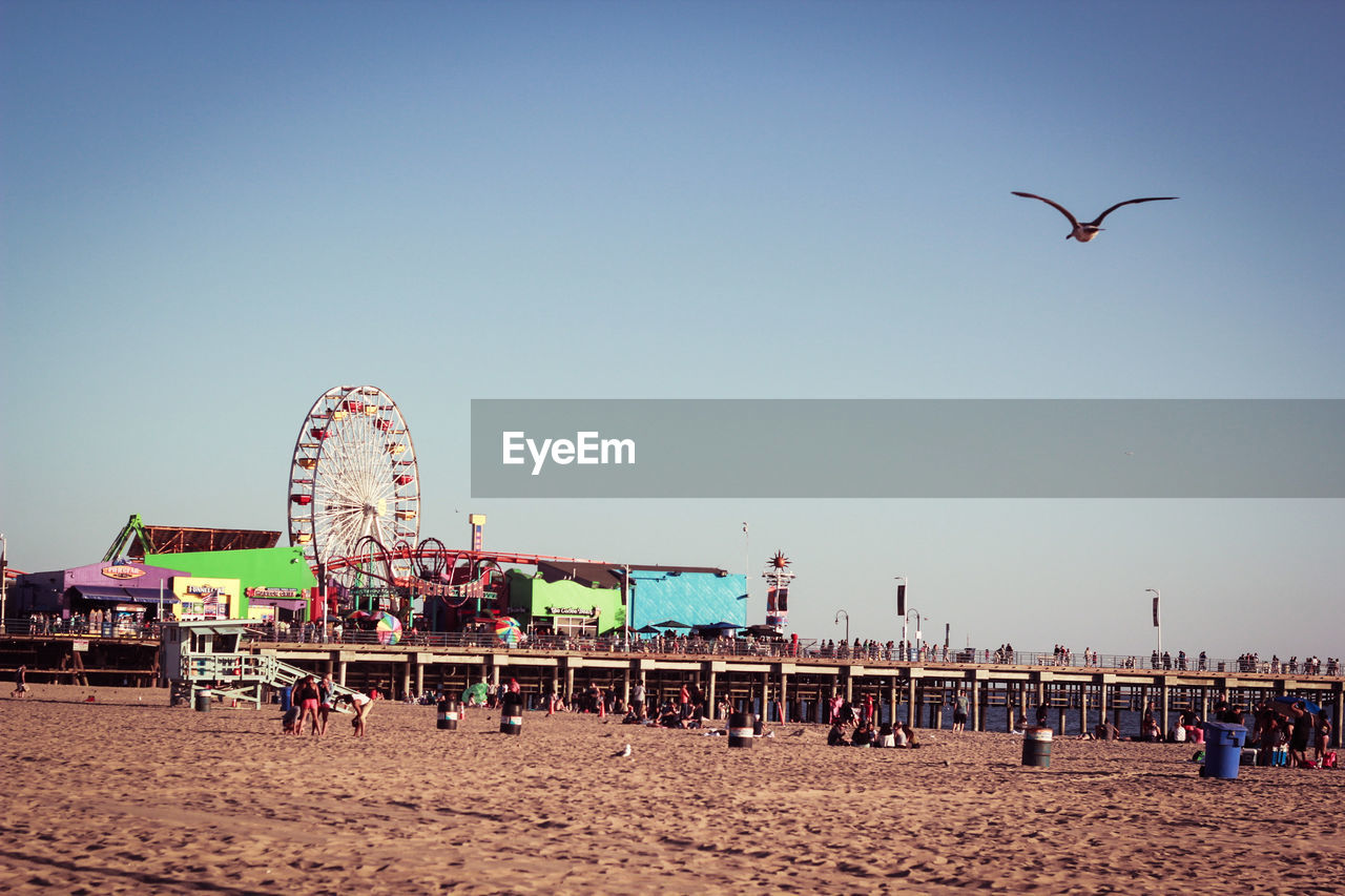 Ferris wheel at beach against clear sky