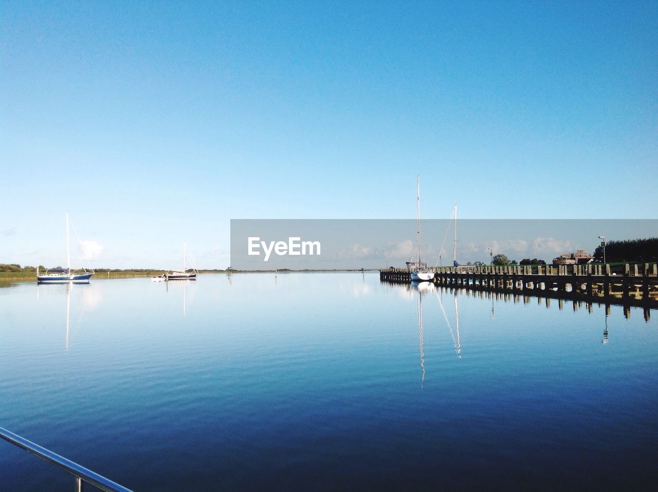 BOATS MOORED ON SEA AGAINST CLEAR BLUE SKY