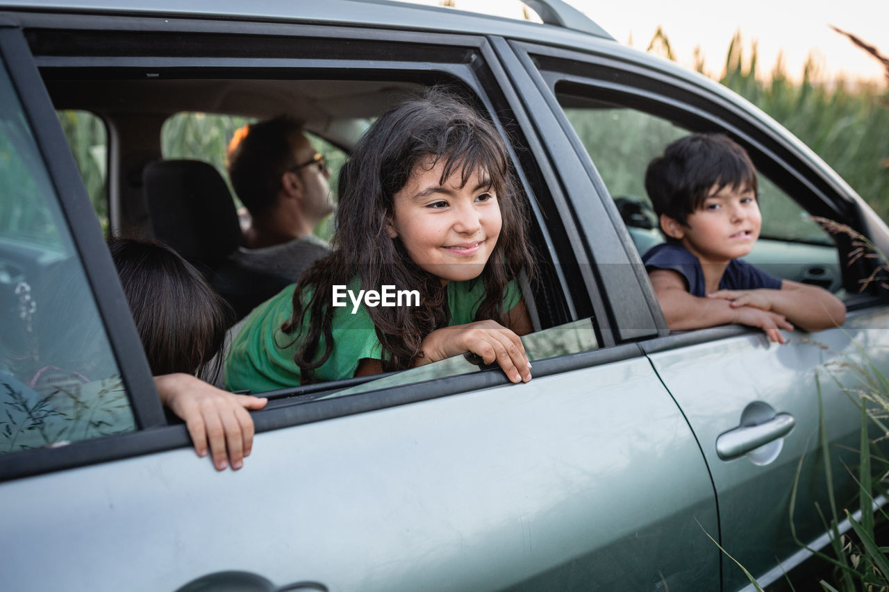 Two girls watching from family car windows