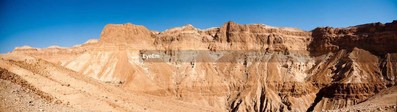 ROCK FORMATIONS ON DESERT AGAINST SKY