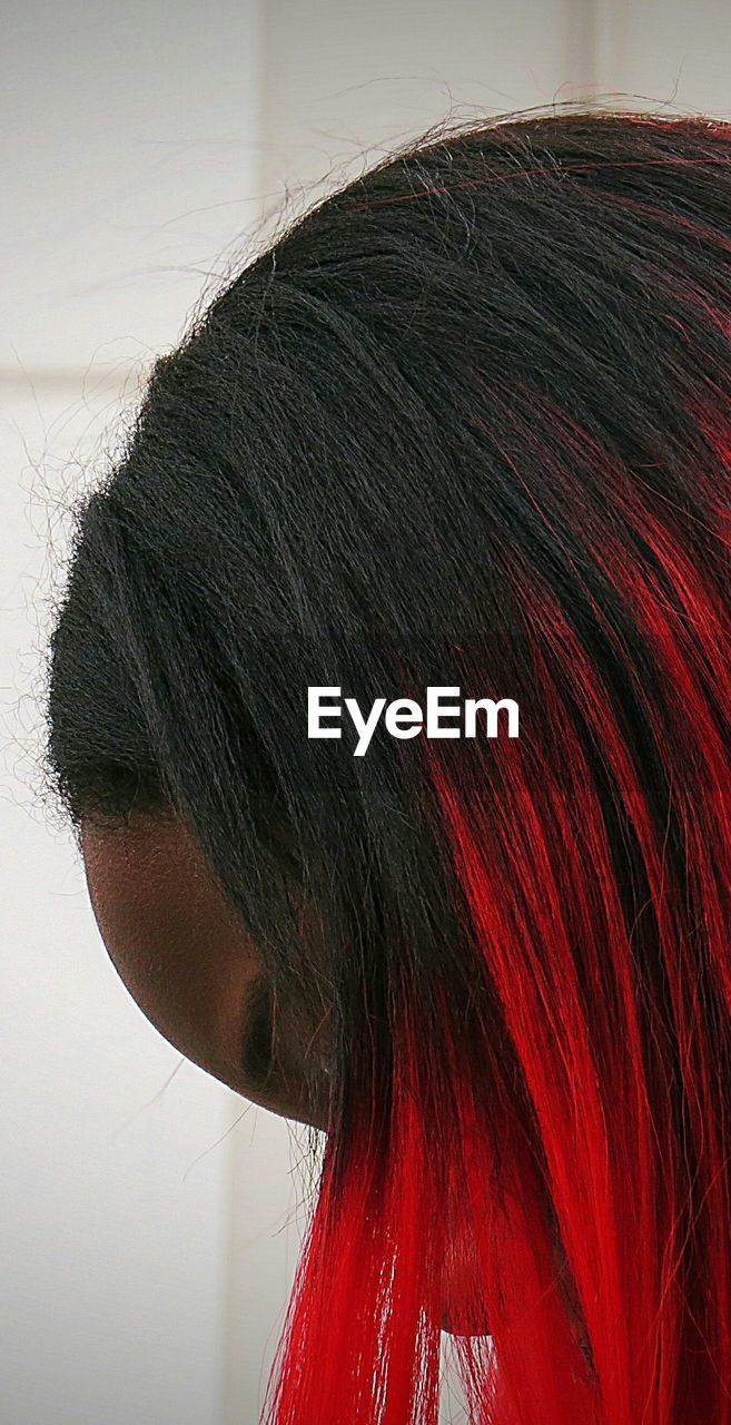 Side view of woman with red dyed hair at home