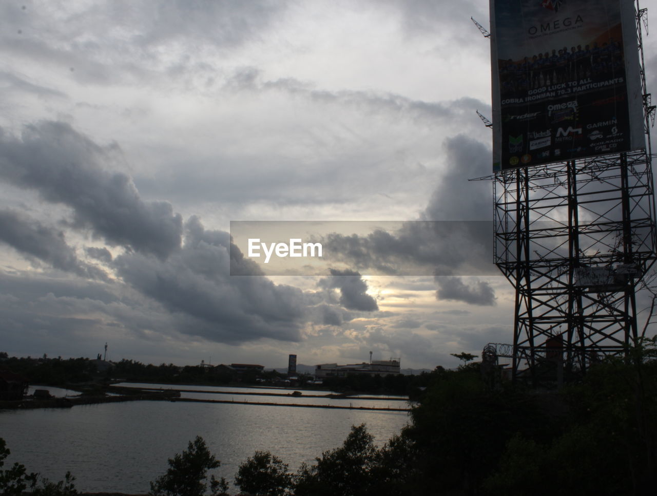 VIEW OF CALM RIVER WITH CITYSCAPE IN BACKGROUND