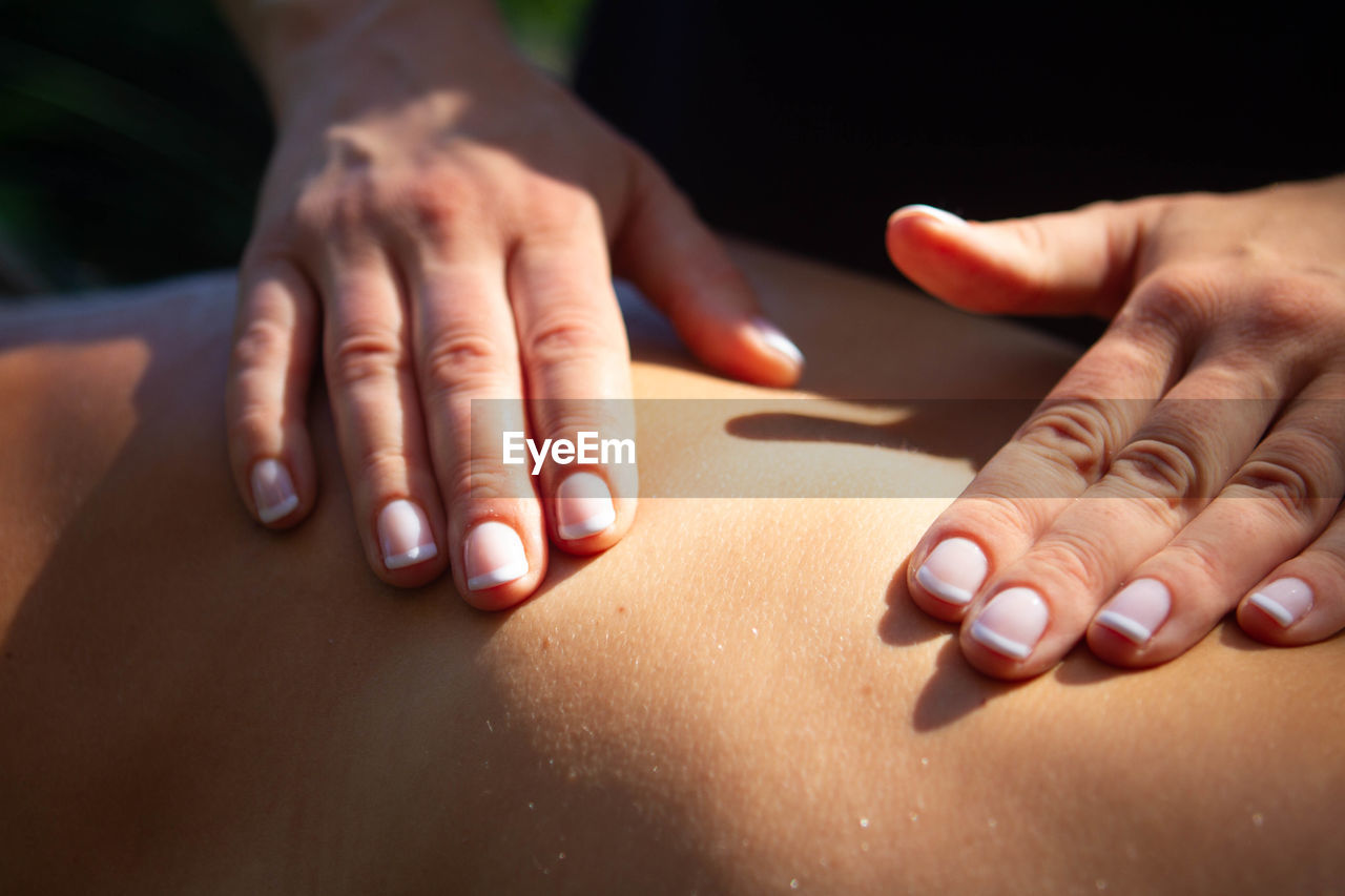 Cropped hands of person massaging customer in spa