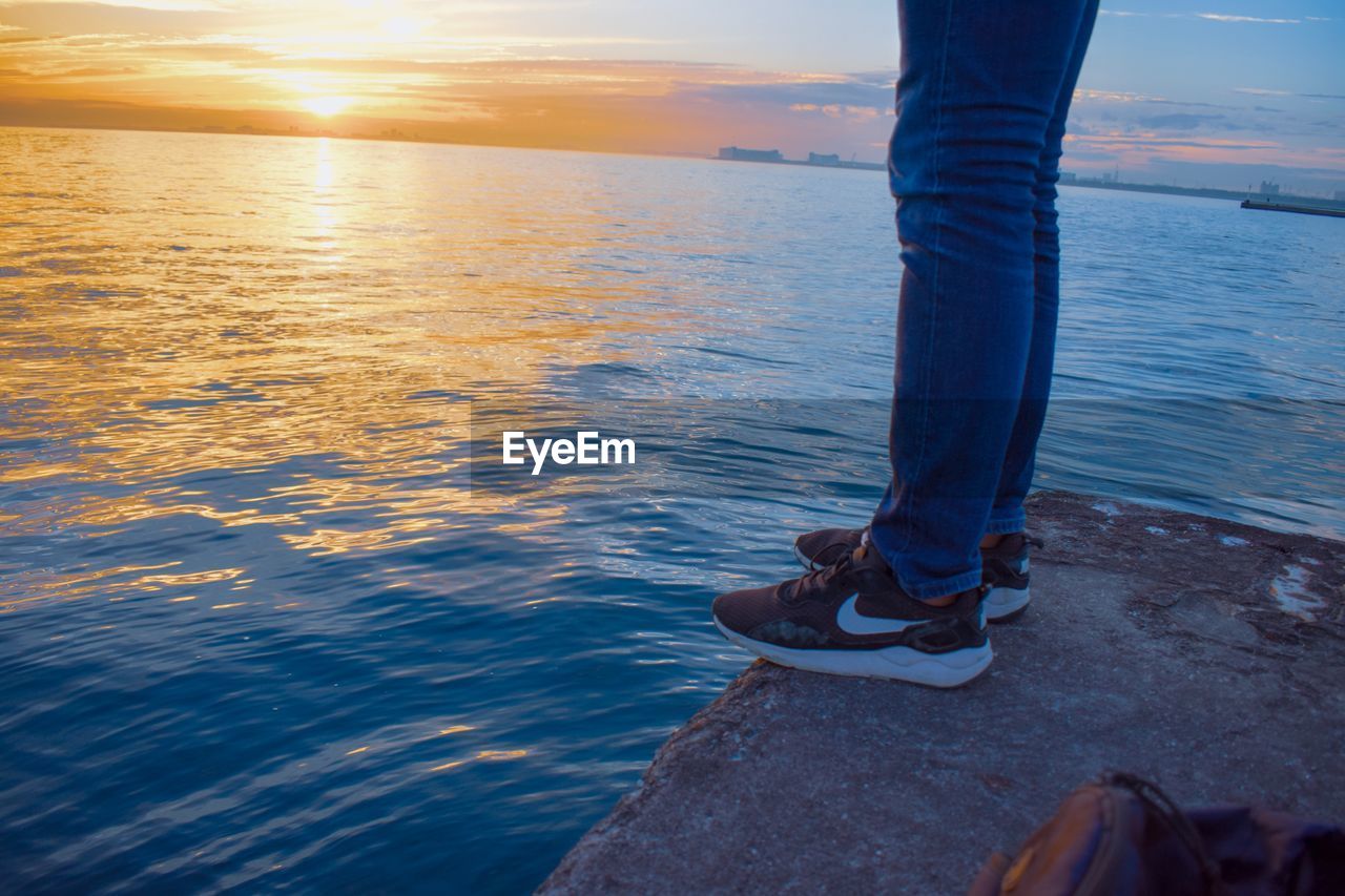 LOW SECTION OF MAN STANDING ON SHORE