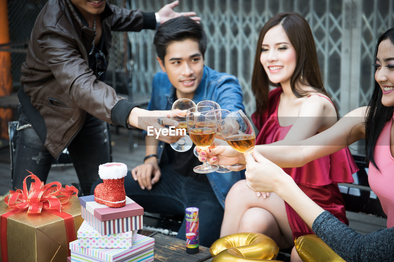 Friends toasting drinks during party