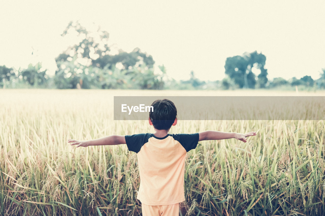 Rear view of boy standing on field