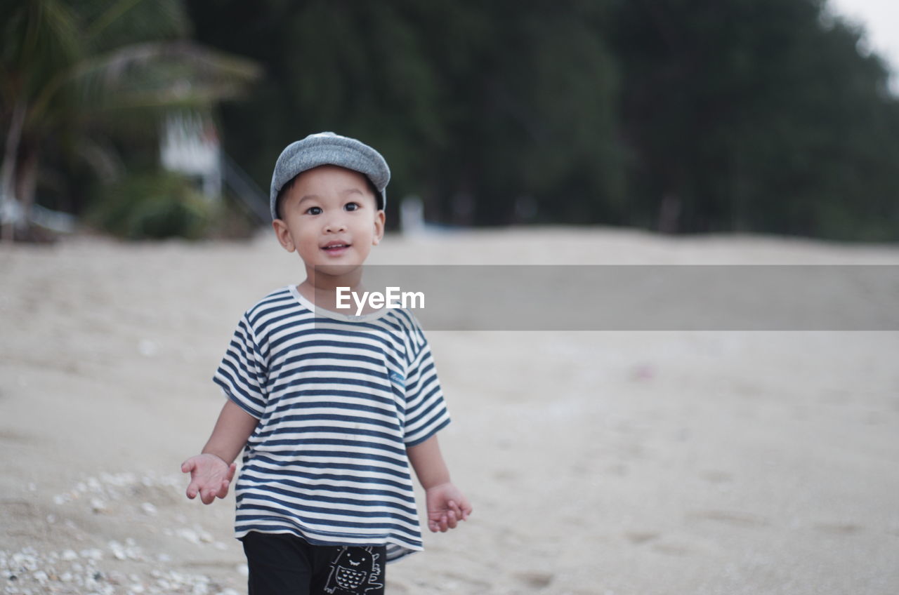 Portrait of cute boy standing at beach