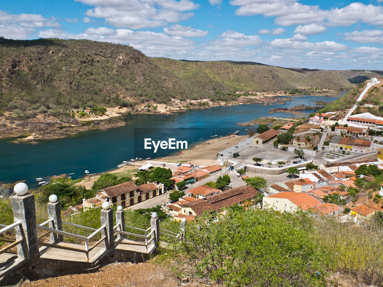 High angle view of town by sea against sky