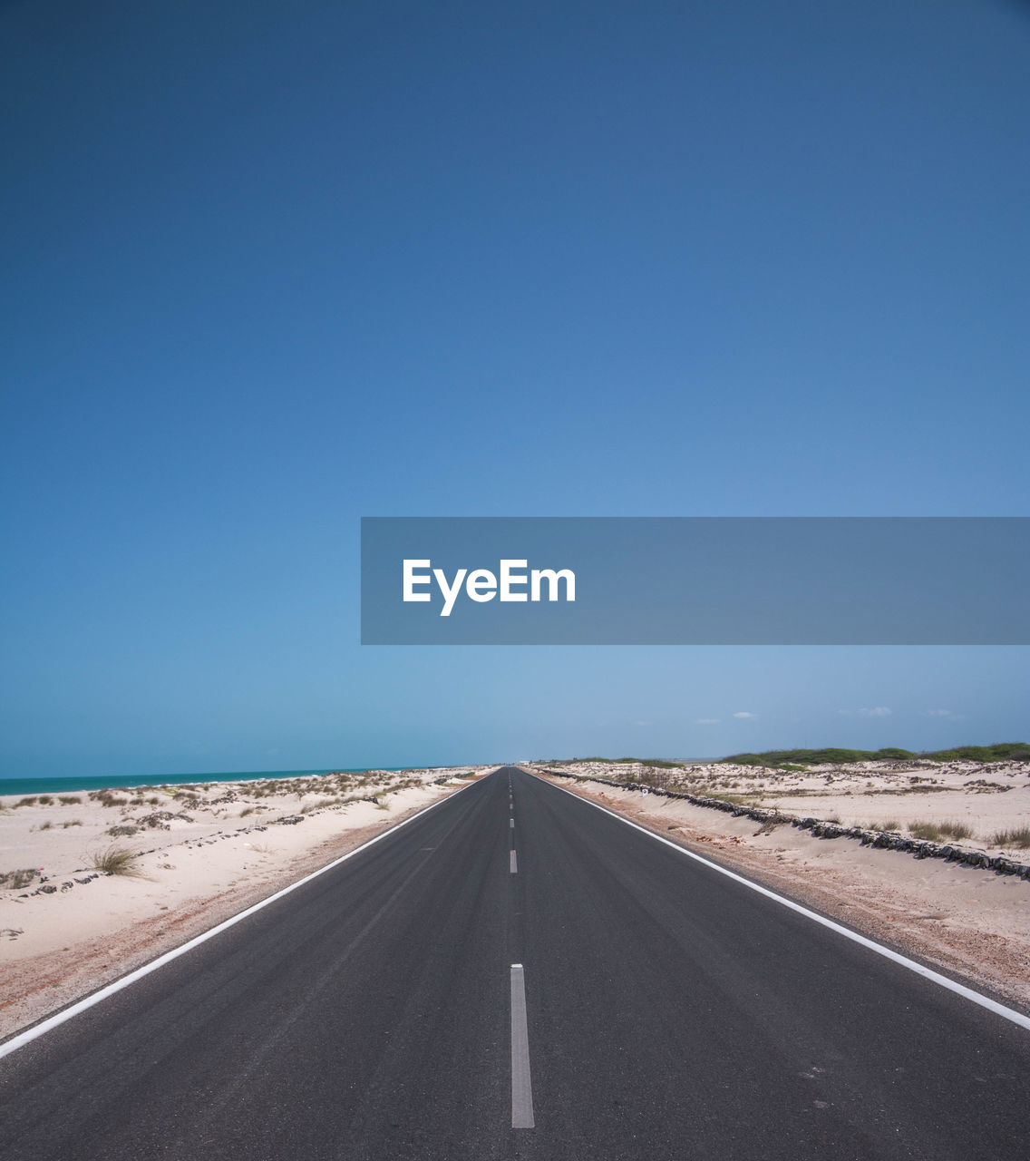 ROAD BY LAND AGAINST CLEAR BLUE SKY