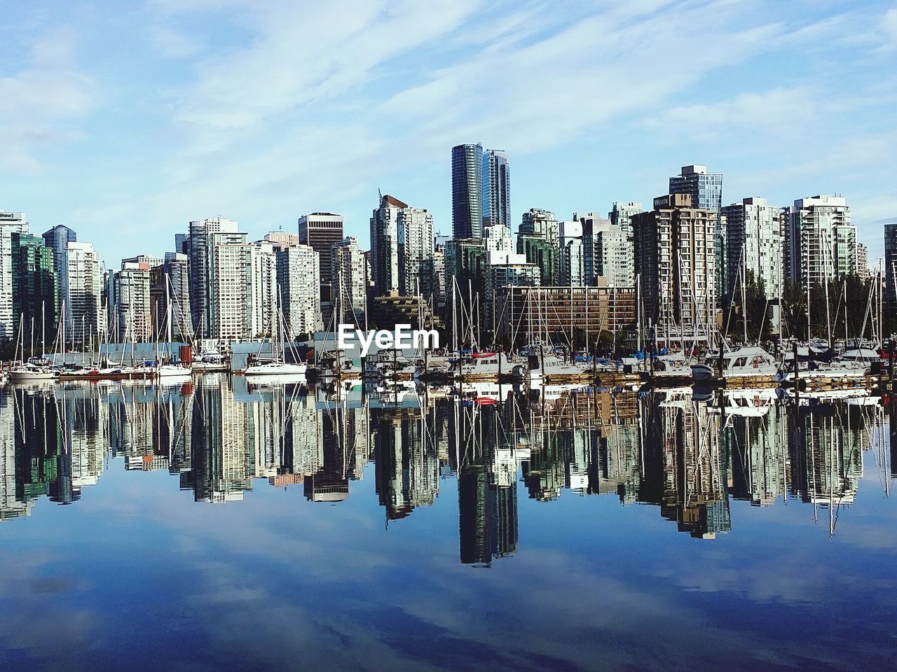 Panoramic view of boats moored in city against sky