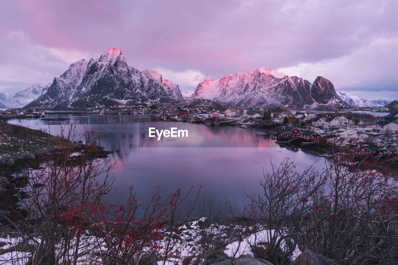 Scenic view of lake and snowcapped mountains against cloudy sky