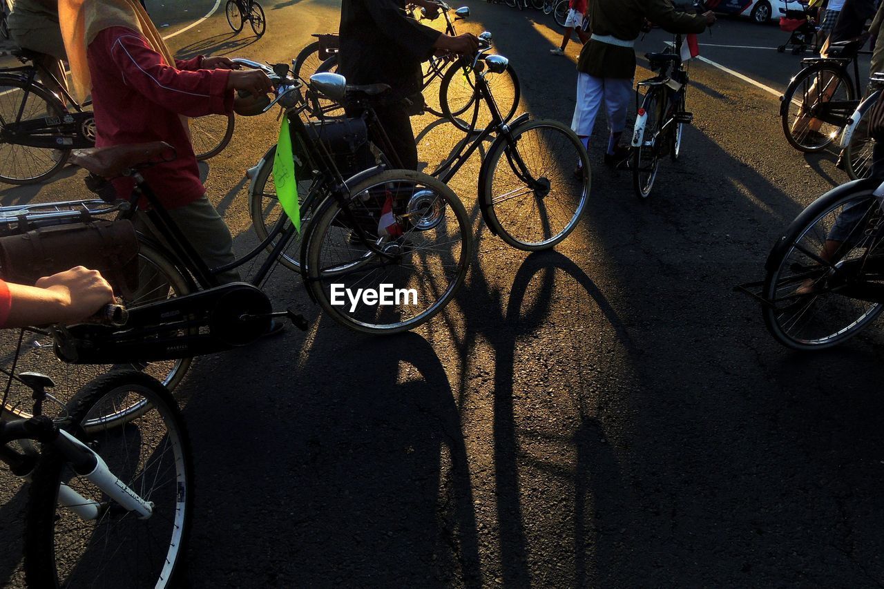 Cropped image of people with bicycles on street