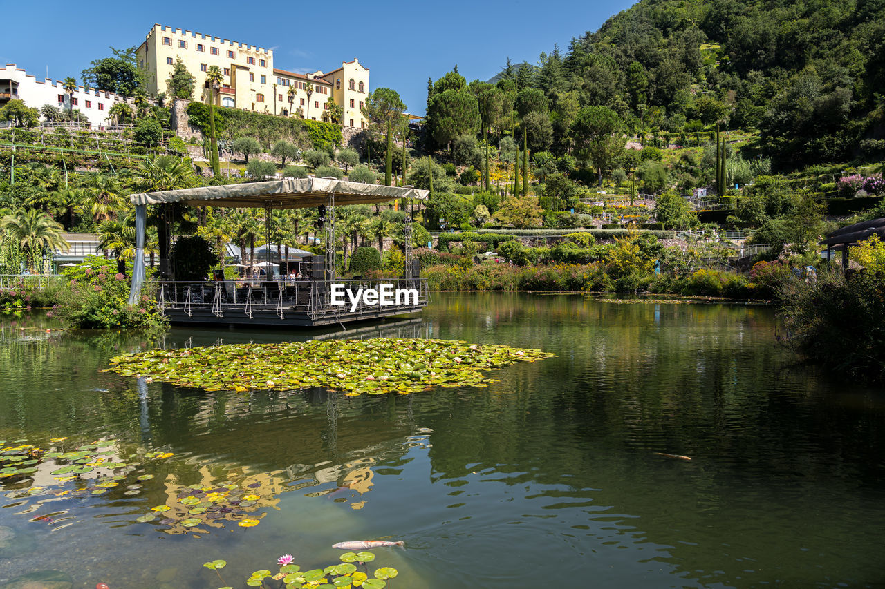 water, reflection, plant, tree, architecture, river, nature, built structure, flower, building exterior, sky, building, travel destinations, pond, travel, beauty in nature, no people, clear sky, tourism, outdoors, body of water, day, nautical vessel, waterway, tranquility, history, house, city, residential district, the past, sunny, transportation, waterfront, autumn, religion, scenics - nature