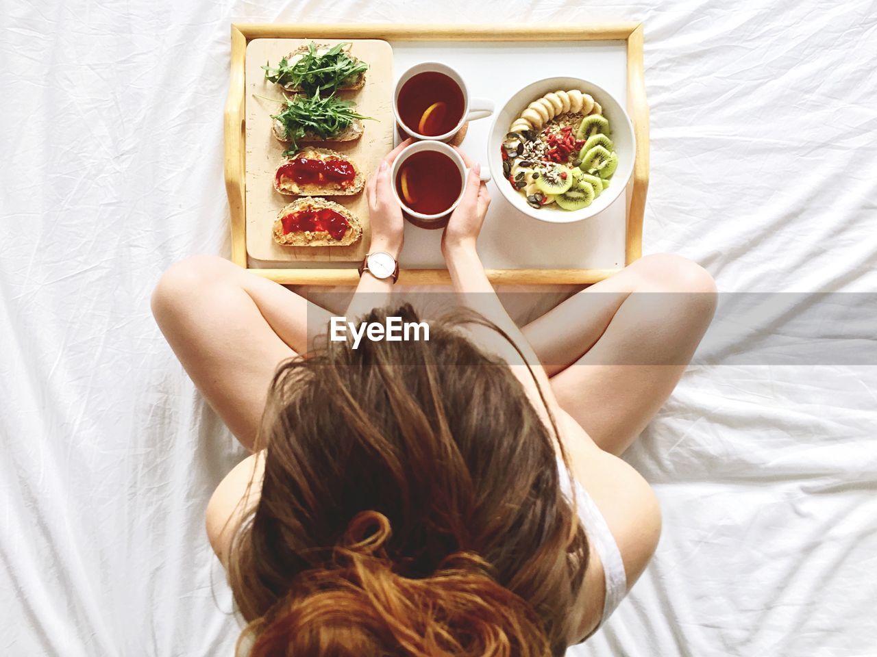 Directly above shot of woman having breakfast on bed