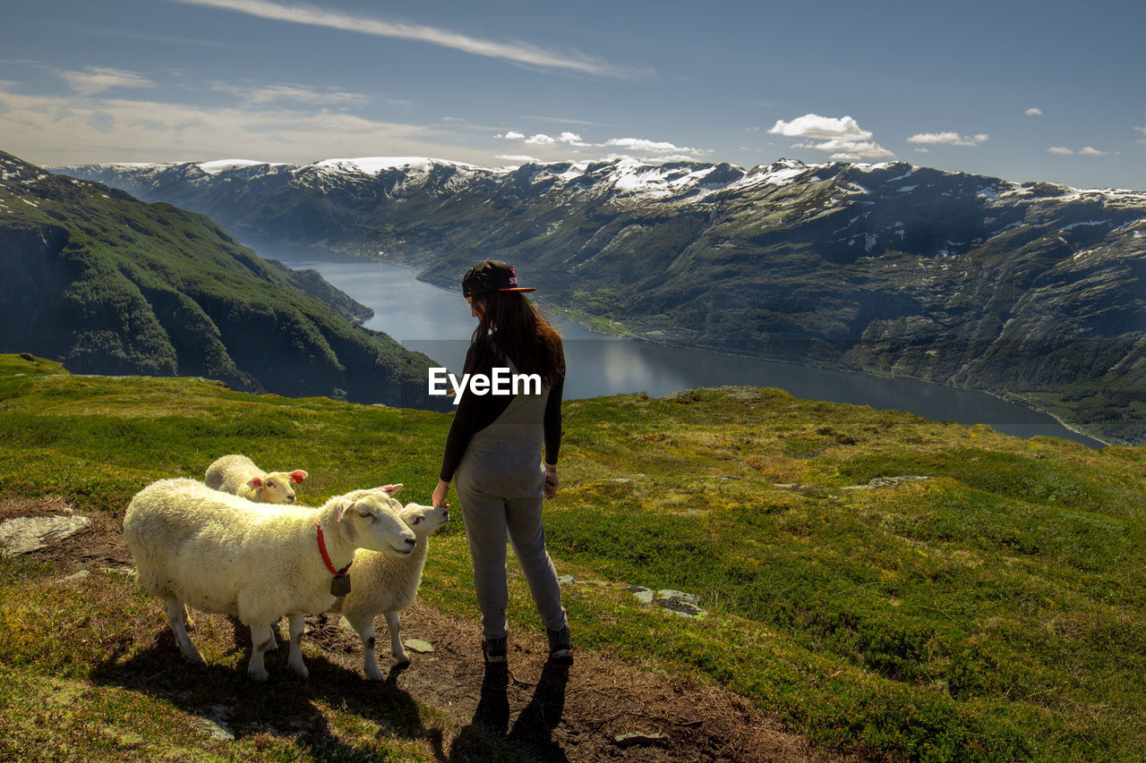 Woman standing with sheep