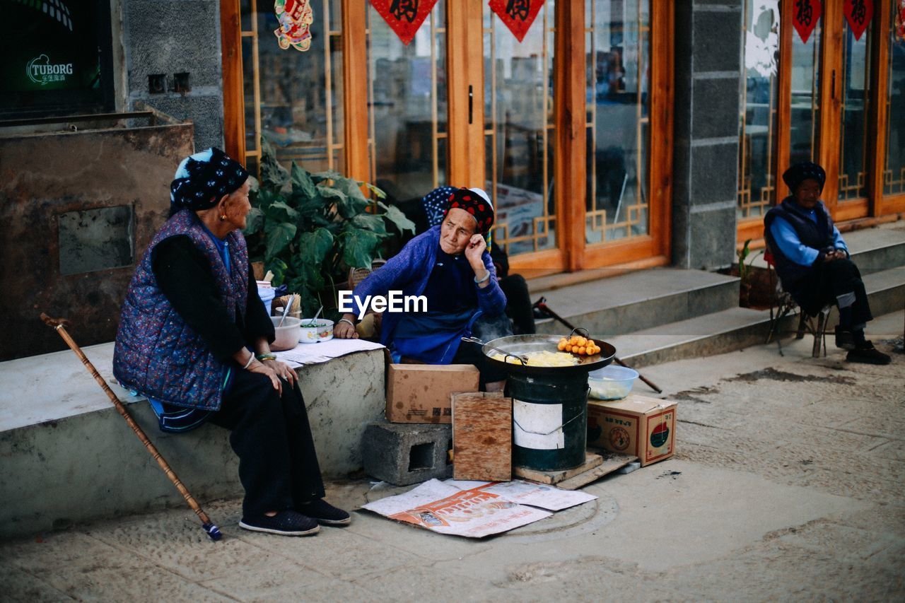 FULL LENGTH OF MAN SITTING OUTDOORS