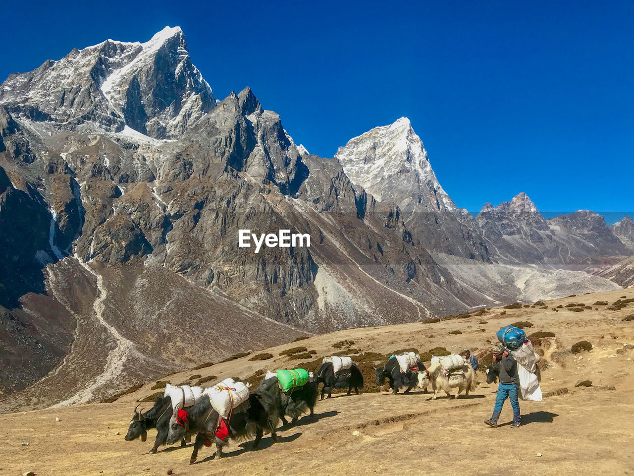 PEOPLE WALKING ON MOUNTAIN AGAINST SKY