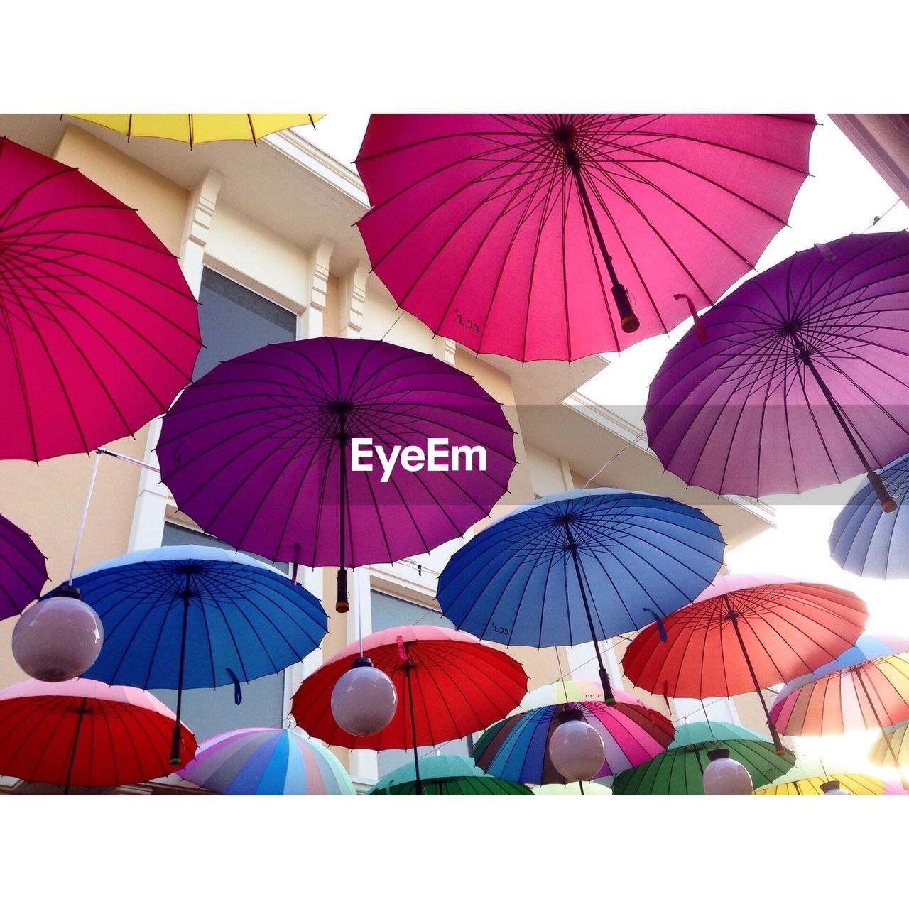 Low angle view of umbrellas hanging against building