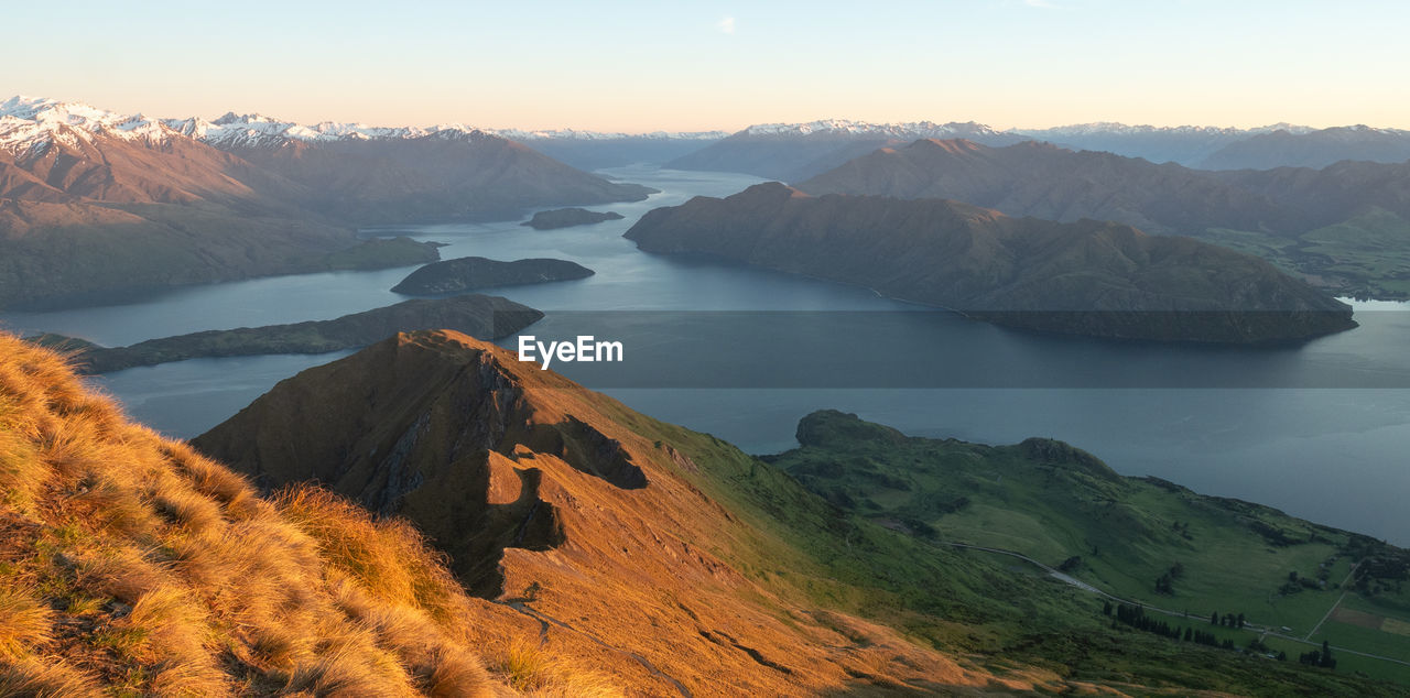 View on lake from mountain summit during sunrise, shot made on roys peak in wanaka, new zealand