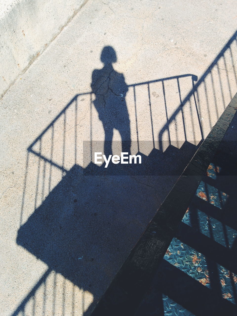 Shadow of woman on steps at road