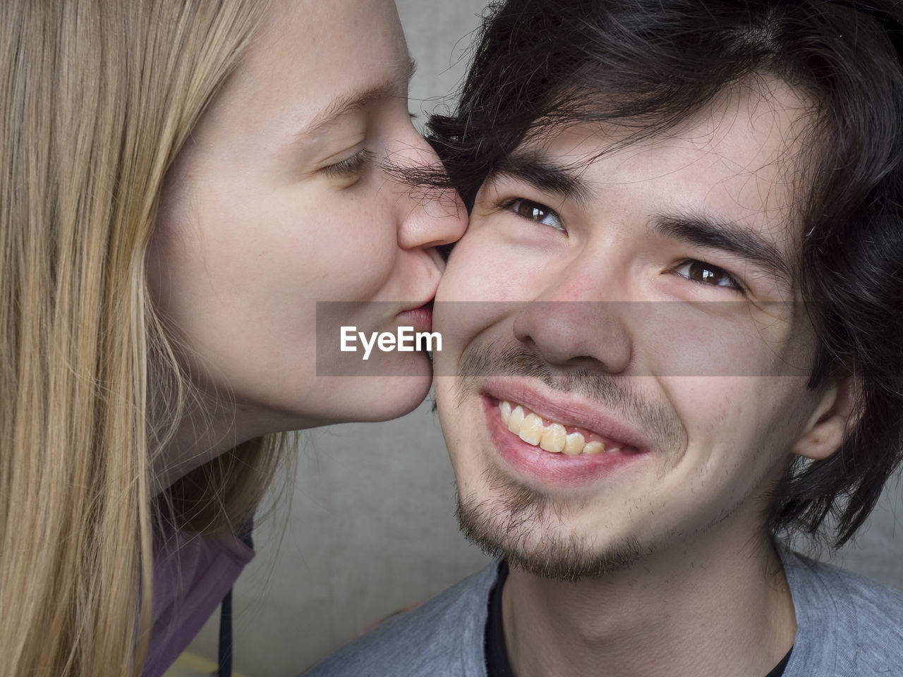 Close-up of woman kissing smiling boyfriend