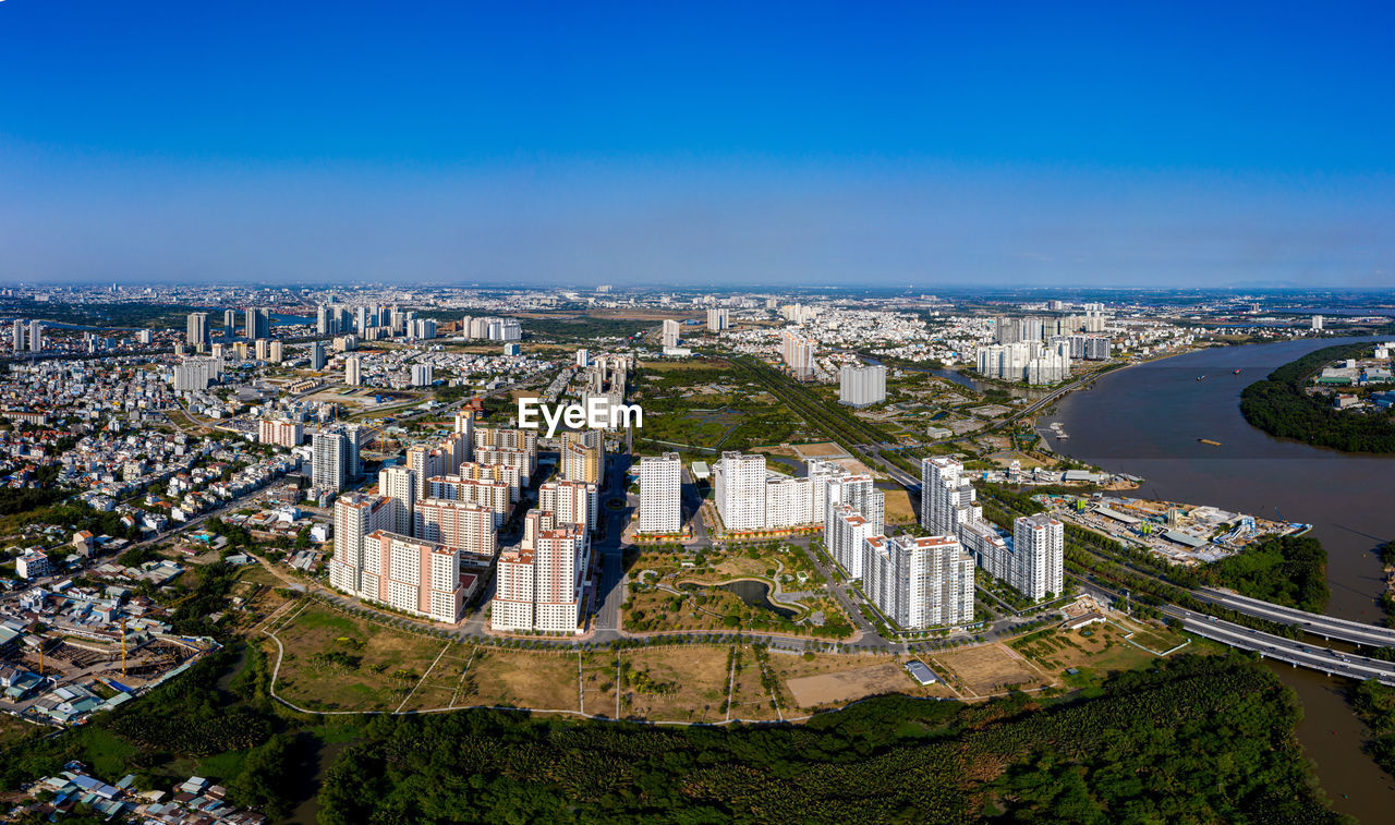 HIGH ANGLE VIEW OF BUILDINGS IN CITY AGAINST BLUE SKY