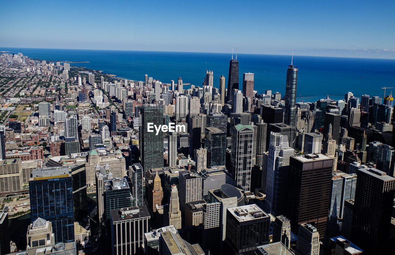 High angle view of buildings by sea in city