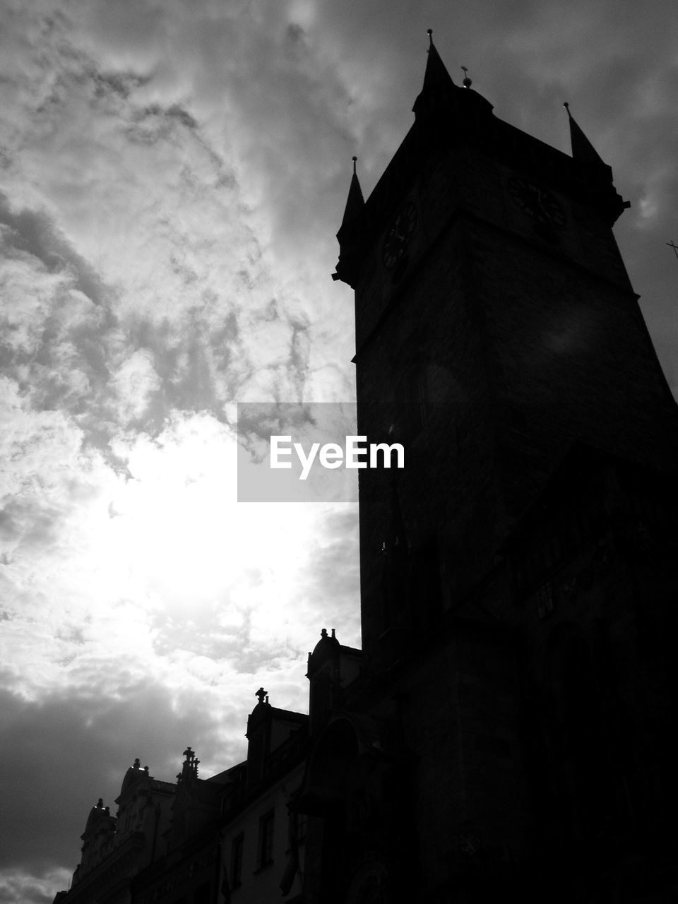 Low angle view of silhouette building against cloudy sky