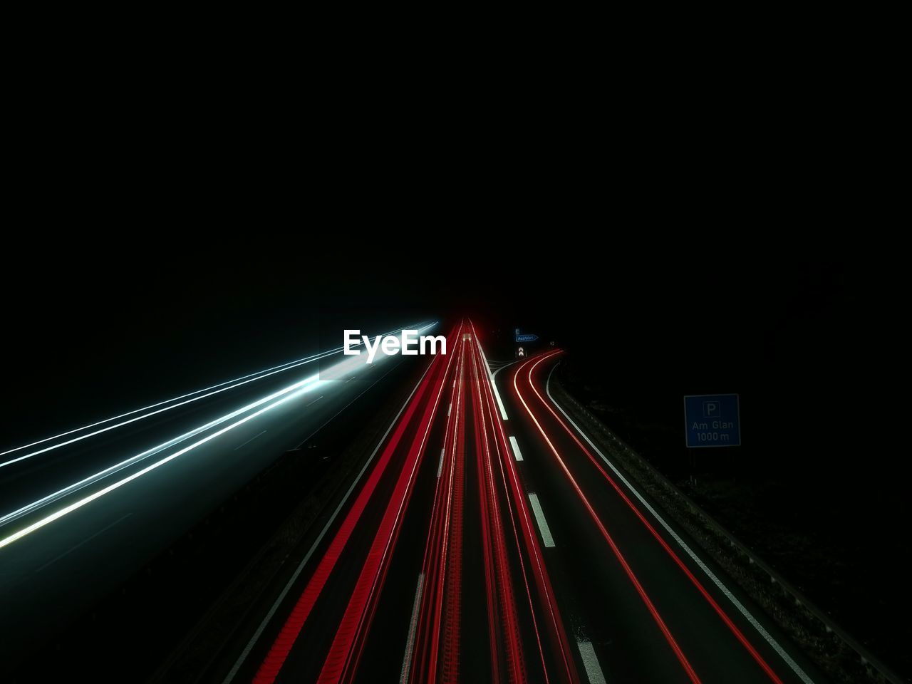 Light trails on road against sky at night