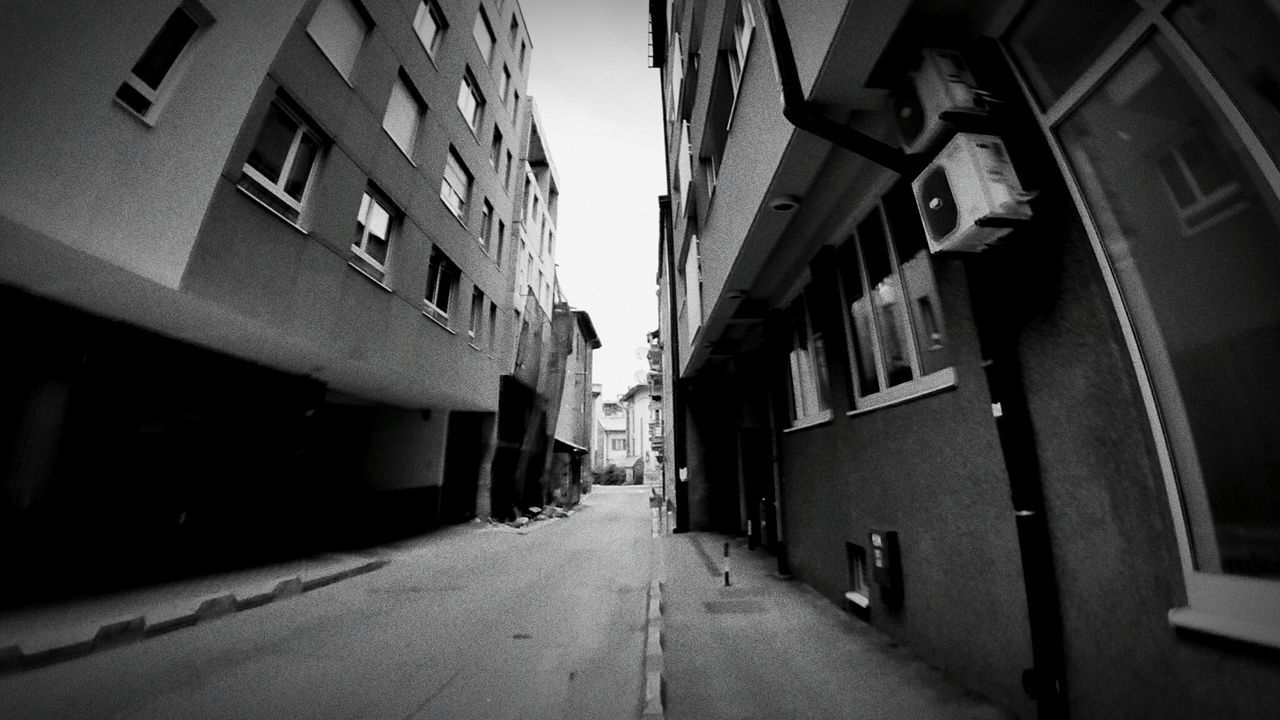 NARROW ALLEY WITH BUILDINGS IN BACKGROUND