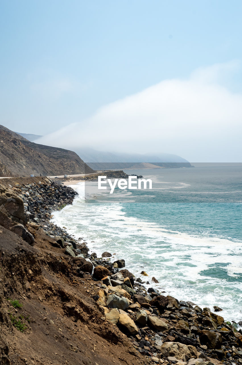 SCENIC VIEW OF SEA SHORE AGAINST SKY