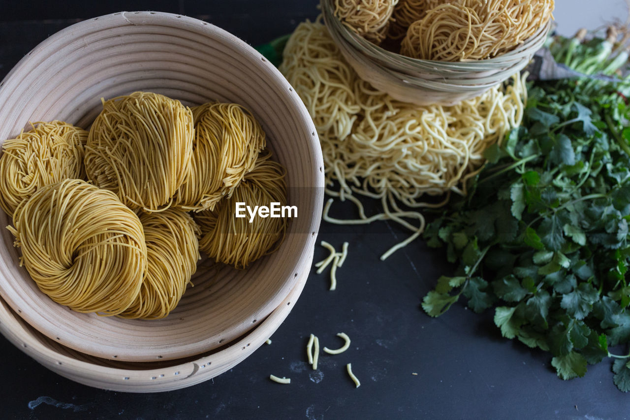 High angle view of dry noodles with parsley on table