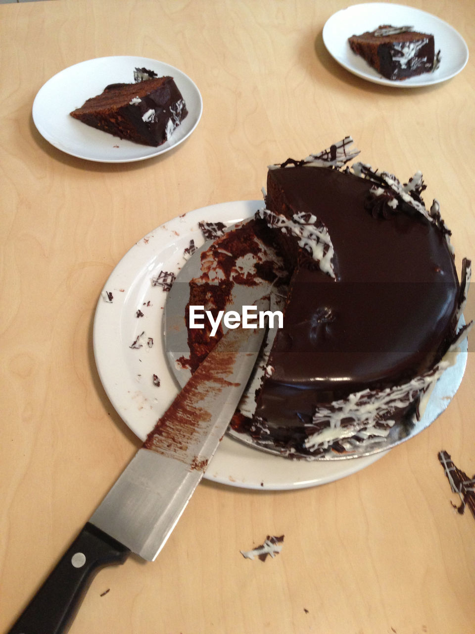 Chocolate cake is cut in slices with a knife
