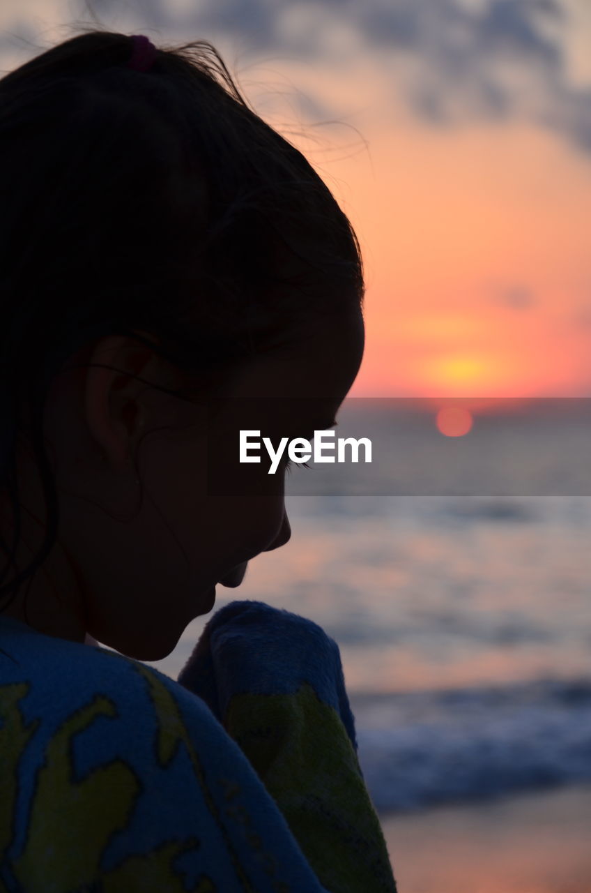 Portrait of woman against sea during sunset