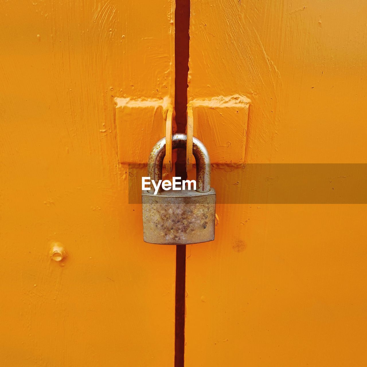 Close-up of padlock on yellow door