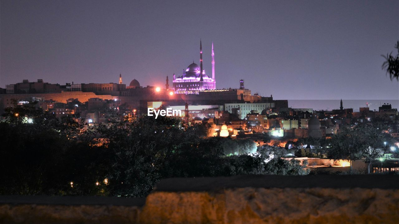 Illuminated city against sky at night