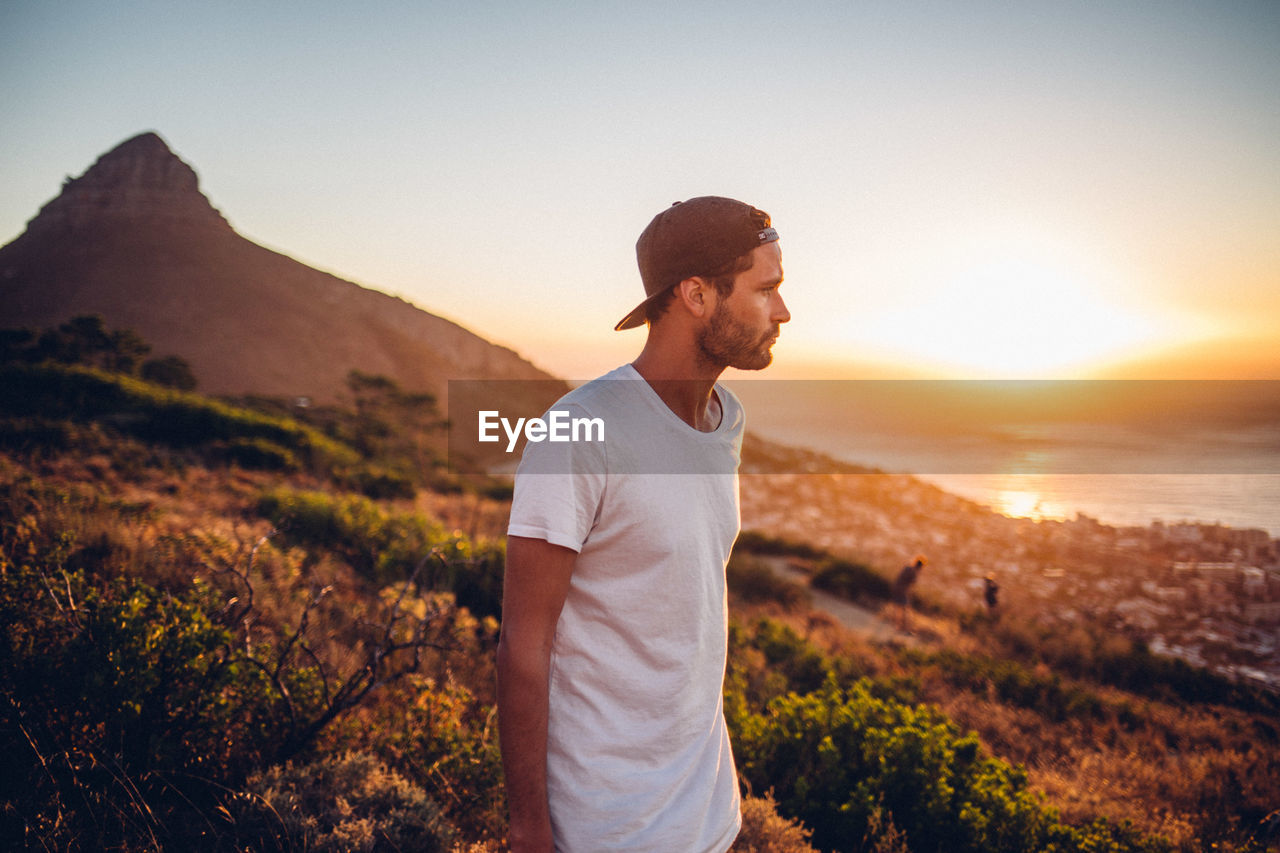 Man standing at beach against sky