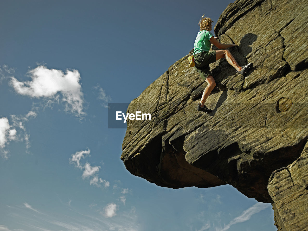 Man bouldering on grid stone in the peak district / uk