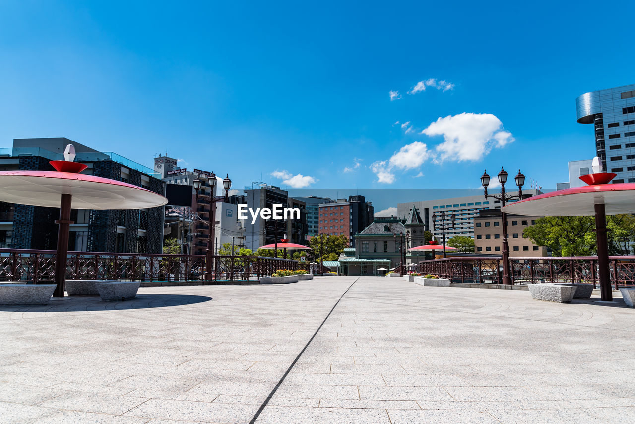 Street amidst buildings against blue sky