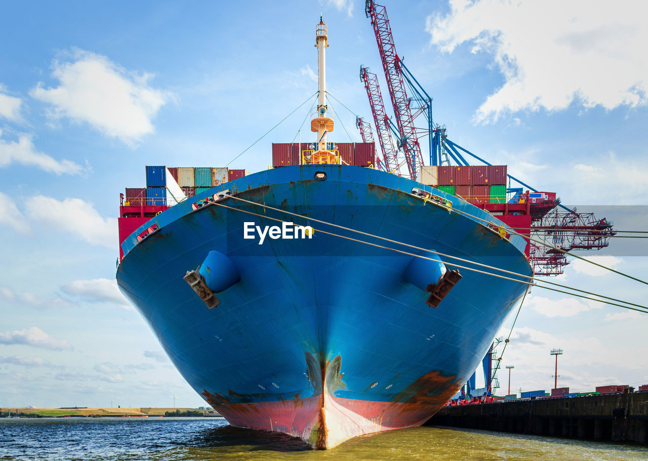 Front of a containership seen from the waterline - center axe view of freight ship being loaded