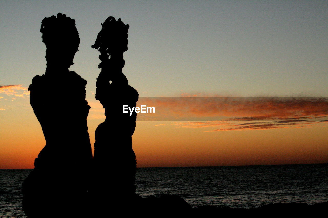 Silhouette people at beach during sunset