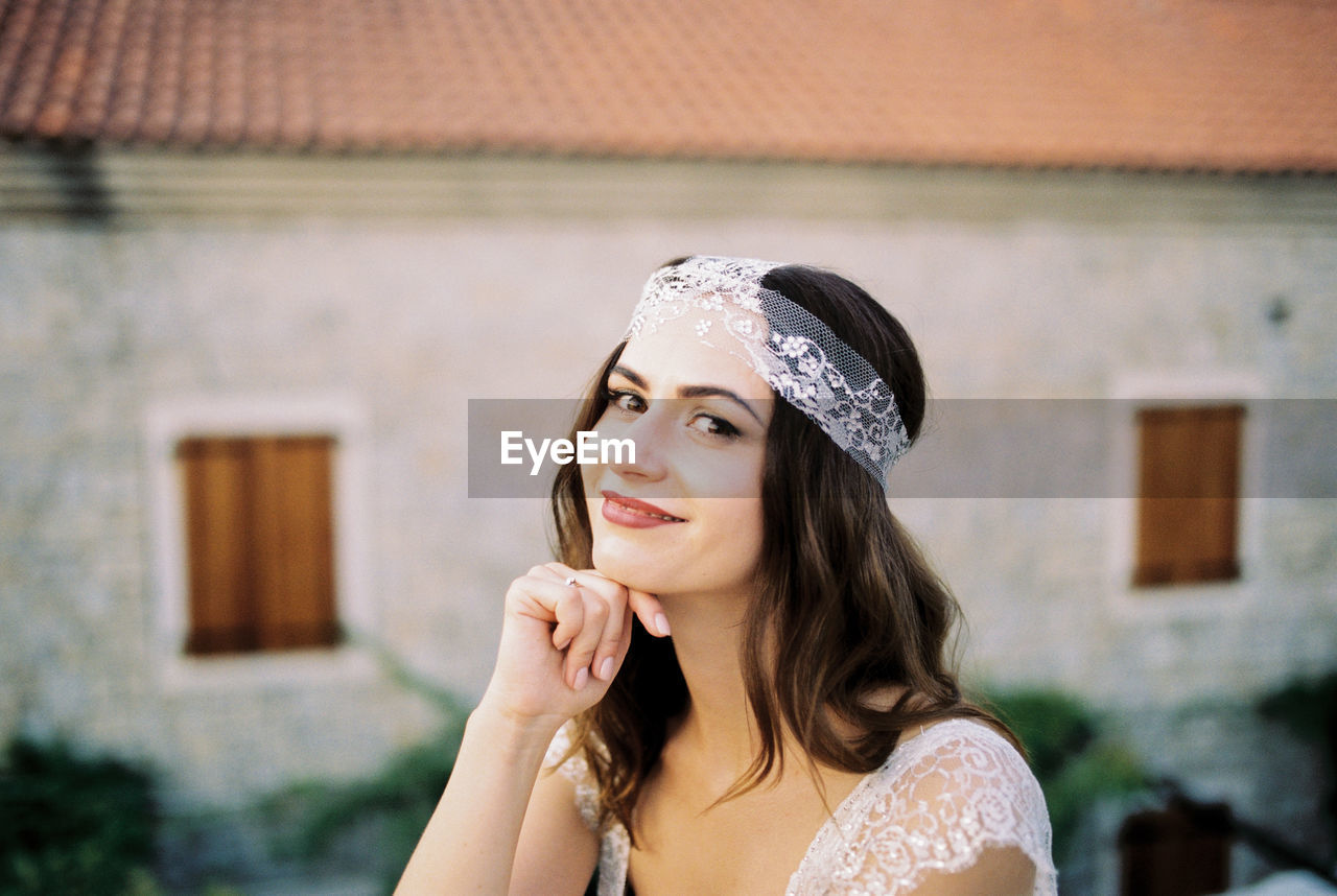 portrait of young woman looking away while standing outdoors