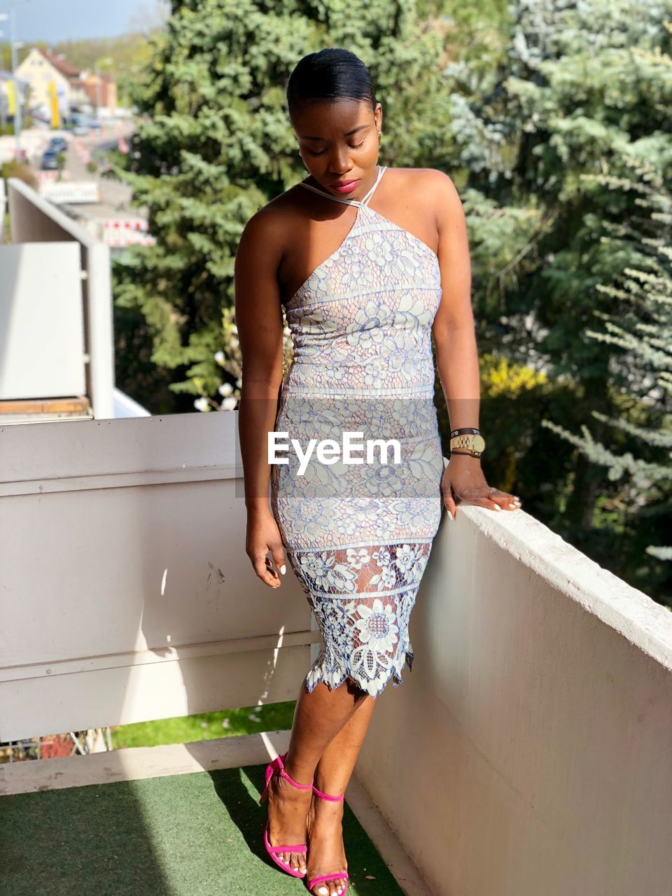 Young woman standing in balcony during sunny day