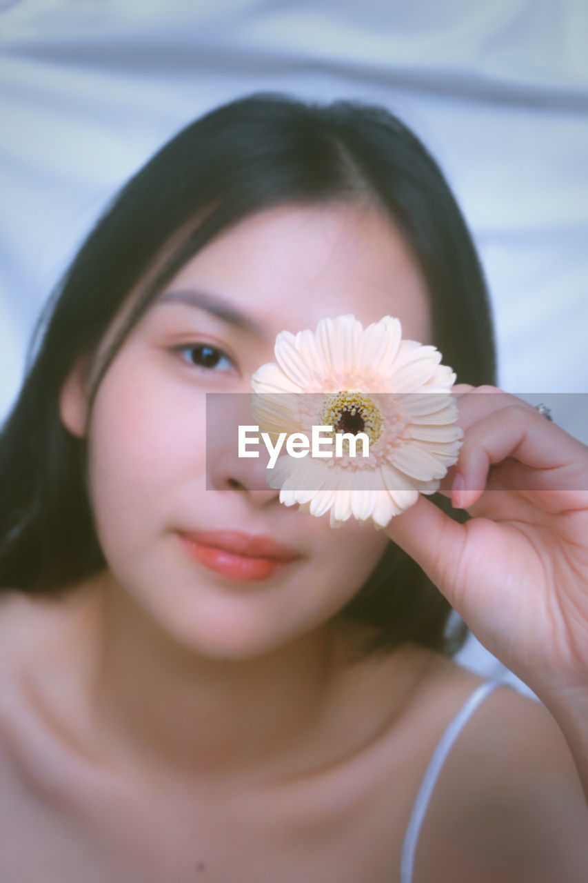 close-up of young woman holding flower