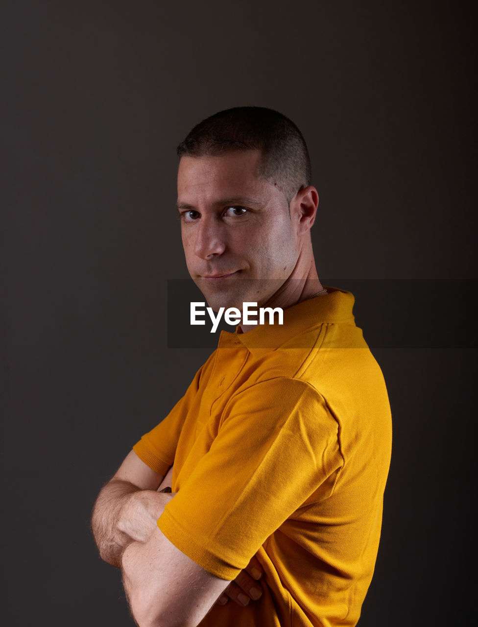 studio shot, one person, portrait, yellow, adult, indoors, athlete, men, black background, young adult, looking at camera, sports, waist up, shaved head, arm, person, lifestyles, clothing, serious, player, exercising, copy space, emotion, sleeve, buzz cut