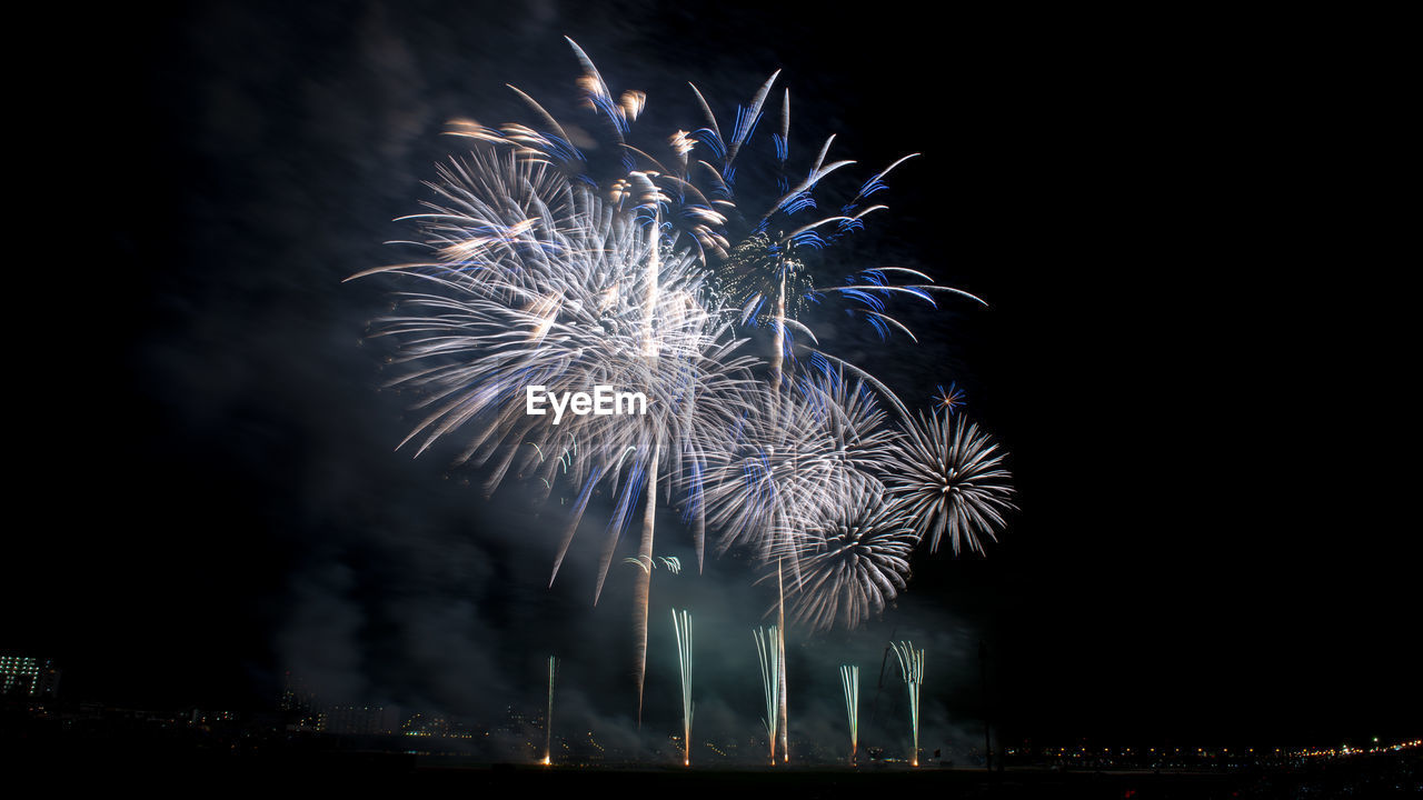 Low angle view of firework display at night