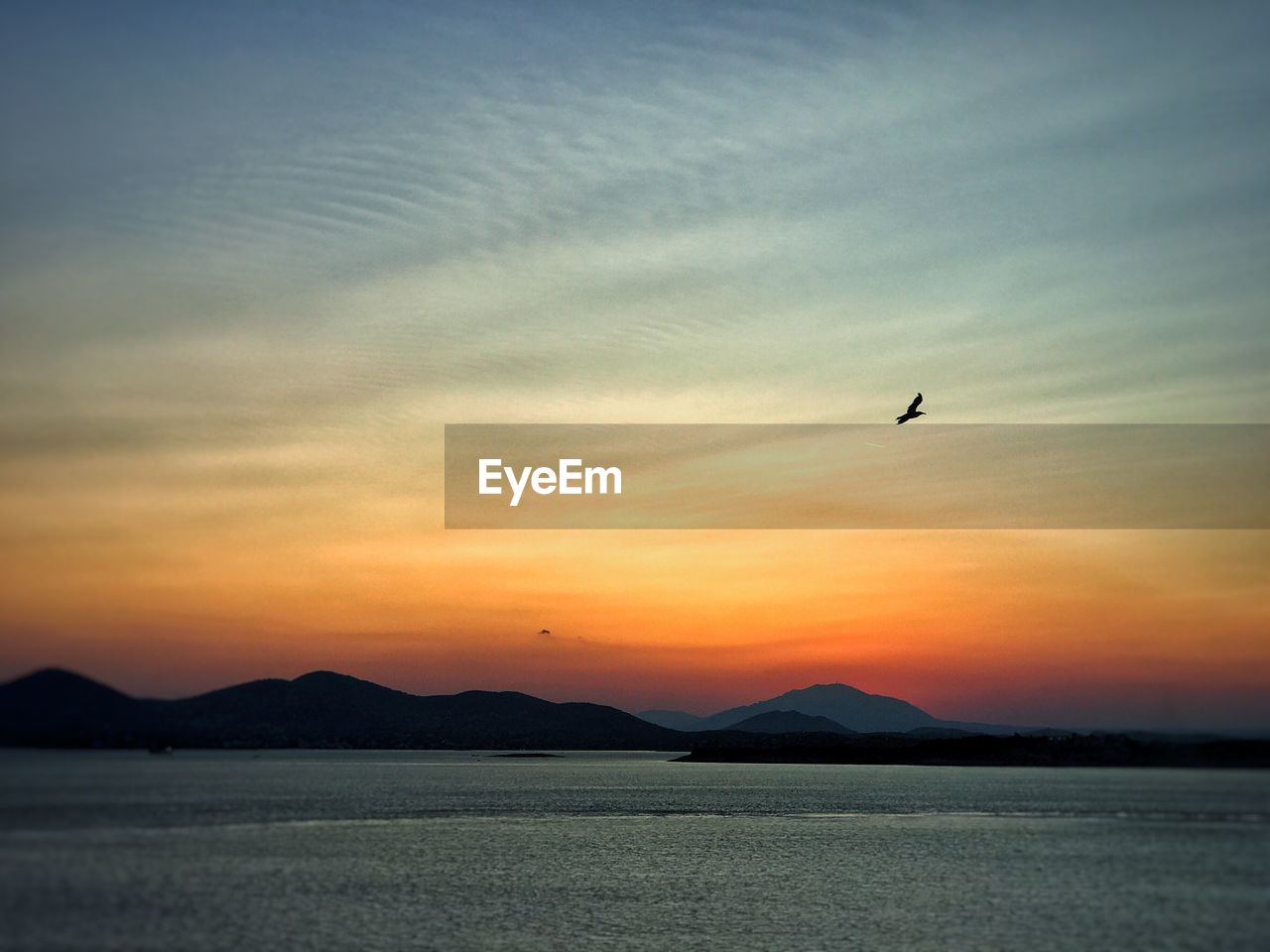 SCENIC VIEW OF SILHOUETTE MOUNTAINS AGAINST SKY AT SUNSET